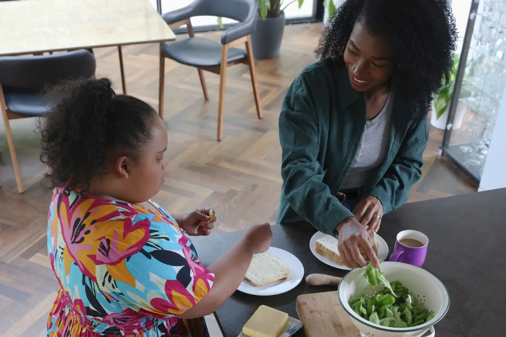 Woman and young disabled girl making a sandwich