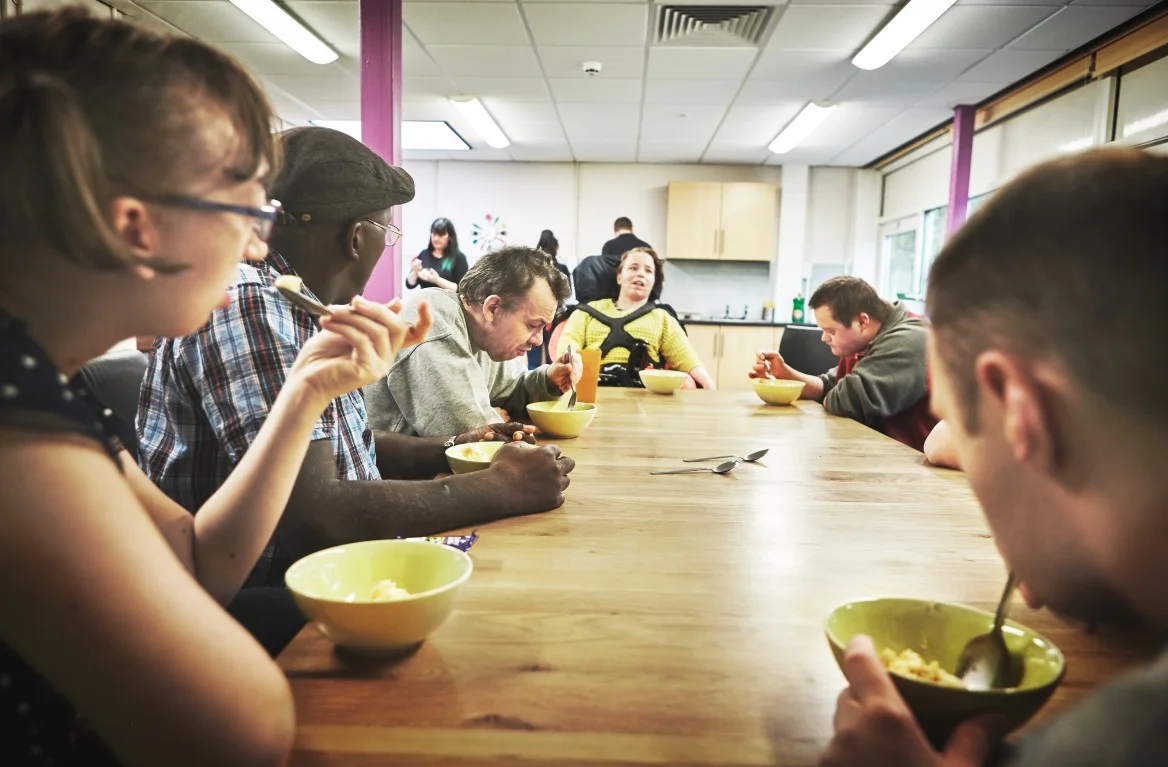 A group of people sitting at the table eating a meal